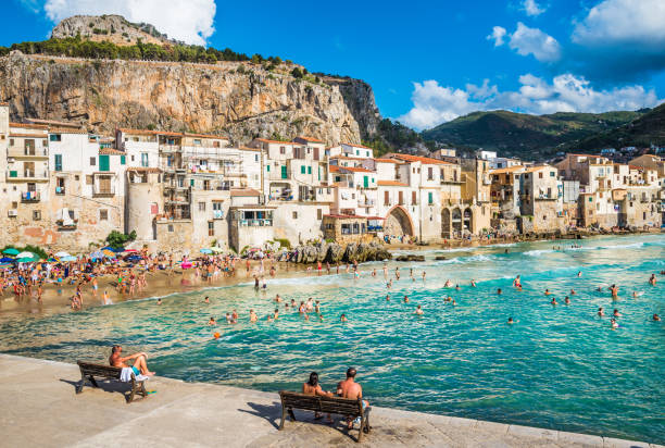 People on beautiful beach at the bay in Cefalu, Sicily.Cefalu is very popular touristic old town in Sicily. CEFALU, SICILY - AUGUST.12. 2017:People on beautiful beach at the bay in Cefalu, Sicily.Cefalu is very popular touristic old town in Sicily. palermo sicily photos stock pictures, royalty-free photos & images
