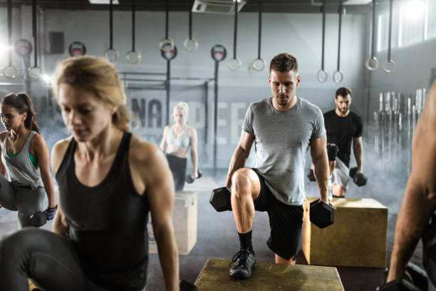 istock Athletic people having cross training with dumbbells in a gym. 1157747590