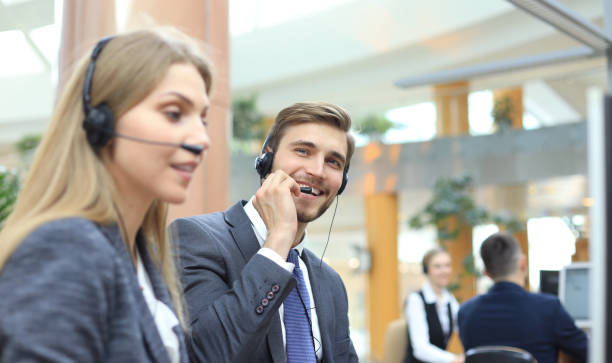 istock Portrait of call center worker accompanied by his team. Smiling customer support operator at work. 1157747766