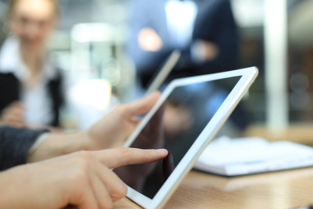 istock Image of human hand pointing at touchscreen in working environment at meeting. 1157748601