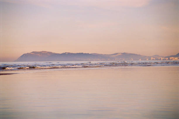 wet beach of Tarifa during a windless summer day, it looks like a mirage on the desert