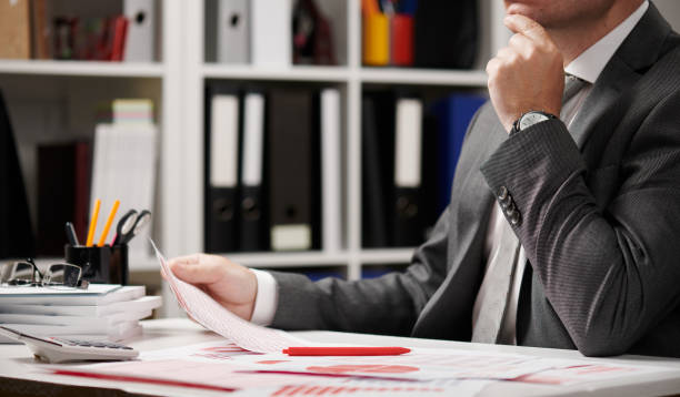 istock Businessman working and calculating, reads and writes reports. Office employee, table closeup. Business financial accounting concept. 1157748747