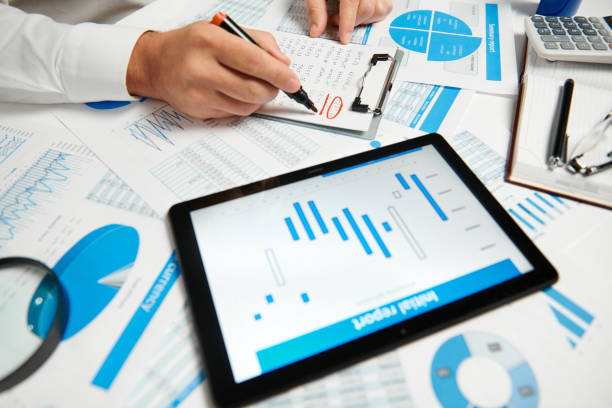 istock Businessman working and calculating, reads and writes reports. Using tablet pc. Office employee, table closeup. Business financial accounting concept. 1157749915