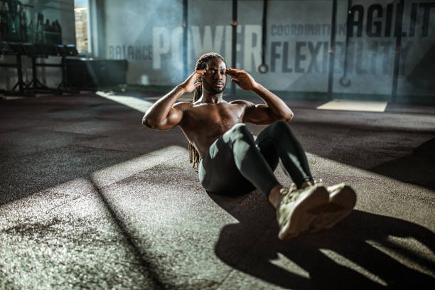 istock Sweaty black athlete doing sit-ups in a gym. 1157750290