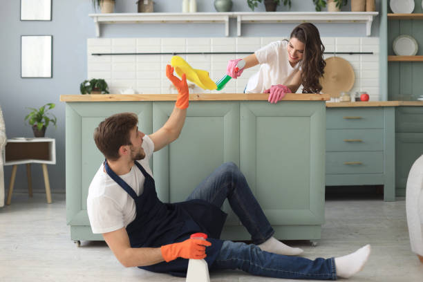istock Young happy couple is having fun while doing cleaning at home. 1157750315