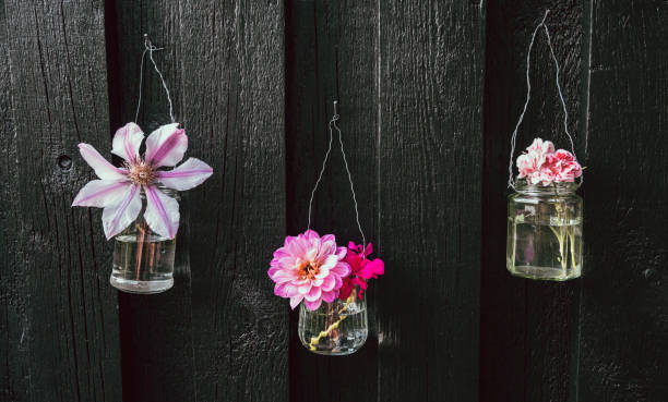 istock Three upcycled flower decorations made from old materials hanging on wall 1157750353