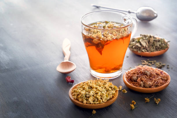 istock Herbal tea with pharmaceutical chamomile on a gray wooden table. 1157751421