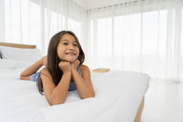 istock Asian girls on a white bed are happy. 1157751468