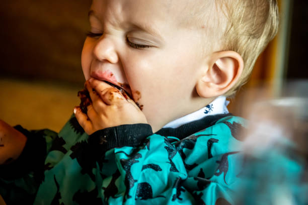 istock Baby boy eating dessert with his hands. 1157752787
