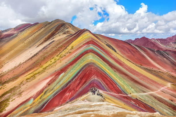 Unidentified  tourists walking on the Rainbow Mountain, Peru.