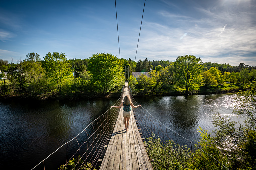 Woman walking on a wire footbridge \