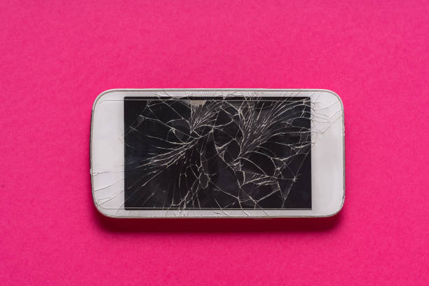 istock Broken mobile phone with cracked display on purple background. 1157753884