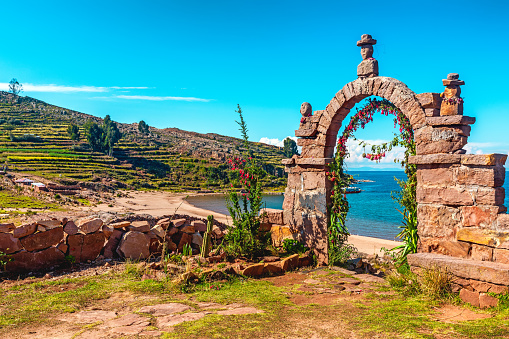 Arco de piedra de entrada que conduce al interior de la isla Taquile en el lago Titicaca, Perú. photo