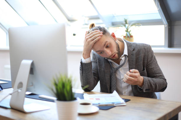 istock Modern businessman thinking about something while sitting in the office. 1157755141