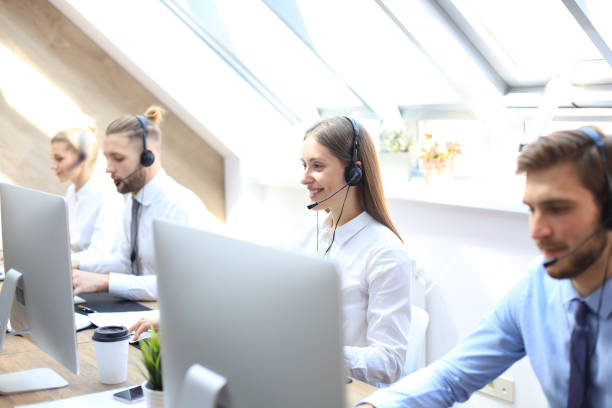 istock Portrait of call center worker accompanied by his team. Smiling customer support operator at work. 1157755553