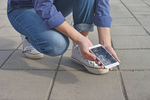 istock Person holding Broken Smart Phone with a cracked screen 1157756618