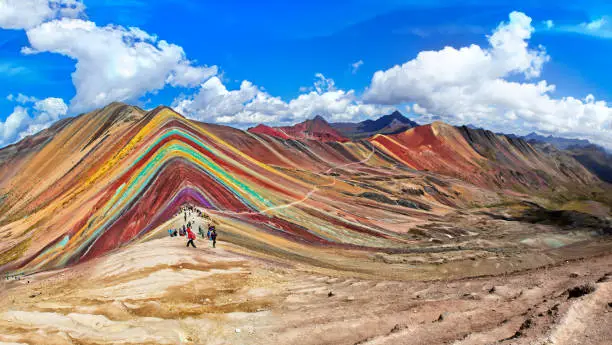 Unidentified  tourists walking on the Rainbow Mountain (Vinicunca Montana de Siete Colores - Spanish) in Cusco, Peru.