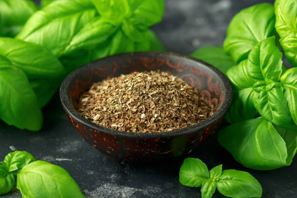 istock Fresh and dried basil in bowl. on black rustic table 1157756840