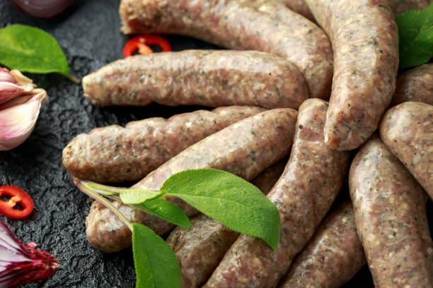istock Butcher made sage and onion sausages with chilli on black background 1157756854