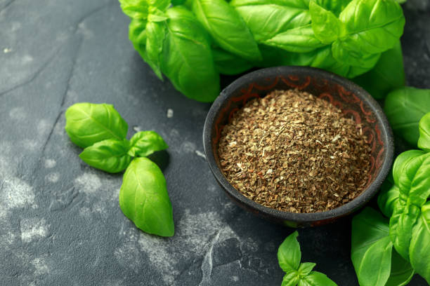 istock Fresh and dried basil in bowl. on black rustic table 1157756865