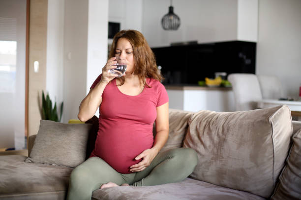 istock Pregnant woman drinking water 1157761677