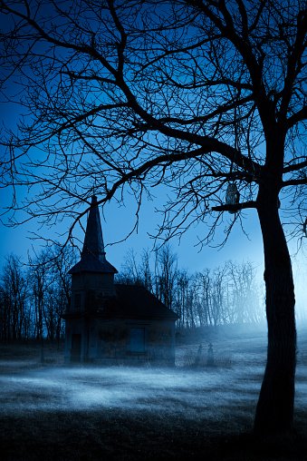 Old chapel on haunted creepy graveyard at night