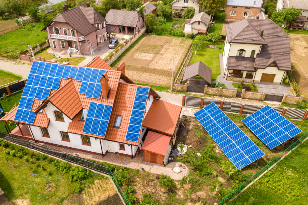 屋根の上に青い光沢のある太陽写真ボルタキのパネルシステムを持つ新しい近代的な住宅のコテージの空中のトップビュー。再生可能なエコロジカルグリーンエネルギー生産コンセプト。 - voltaic ストックフォトと画像