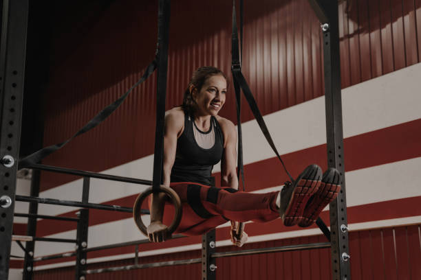 istock Cheerful  woman doing abs exercises on gymnastic rings 1157765228