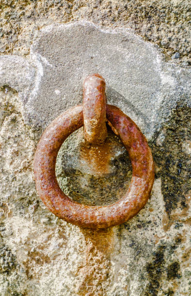 istock Rusted steel mooring ring on cement in rock wall. 1157765509