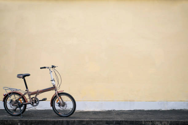 istock Folding bike parked in front of yellow wall 1157765557