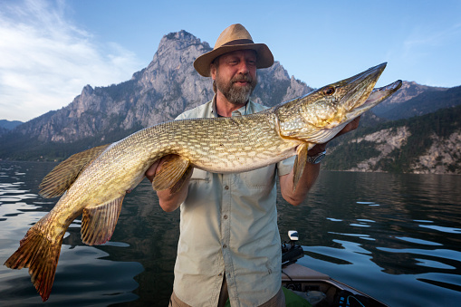 Fisherman fishing in a lake in the mountains