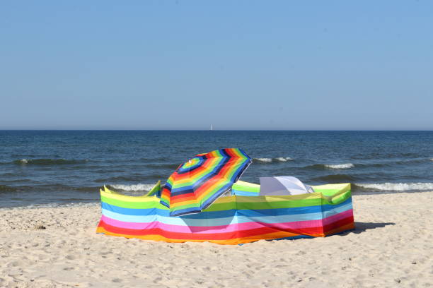 istock Colorful wind blocker and umbrellas on the beach 1157769142