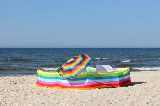 Colorful wind blocker and umbrellas on the beach