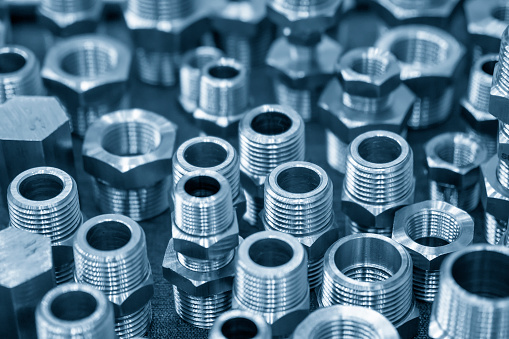 Close-up of the screw fitting connector parts for pipeline processing. The pipeline parts manufacturing process.