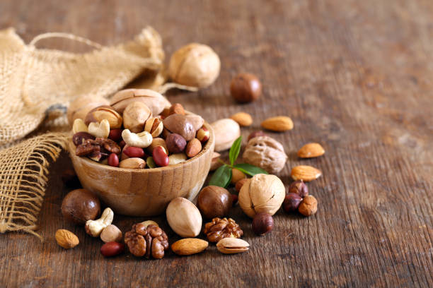 nueces de mezcla orgánica - close up table brown dieting fotografías e imágenes de stock