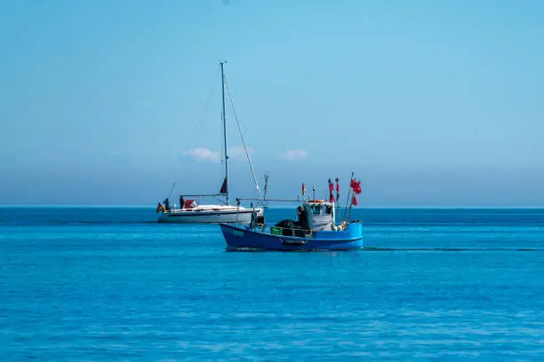 Fishing boat with red flags on the baltic sea near Heiligendamm and Kuehlungsborn