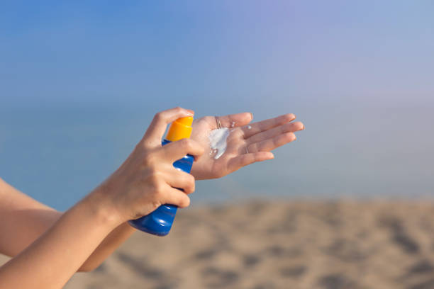 istock Woman hand apply sunscreen on the beach 1157785898