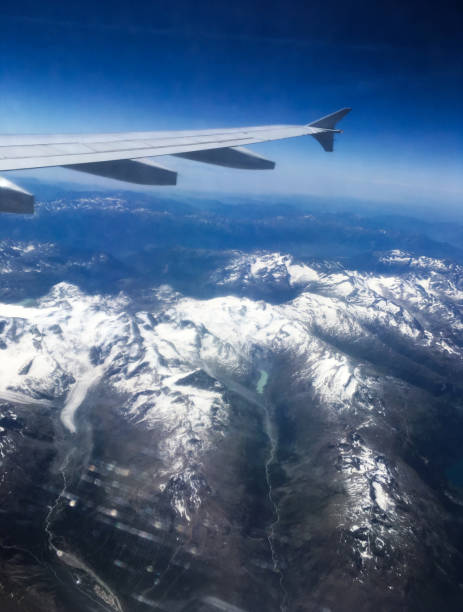 飛行機の翼とスイスアルプスの航空写真。氷で覆われた尾根 - mountain range earth sky airplane ストックフォトと画像