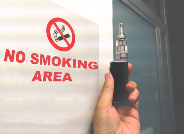 istock electronic cigarette in no smoking area hand sign 1157787437
