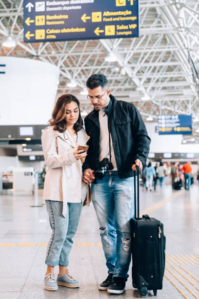istock Couple using smartphone at the airport 1157787812