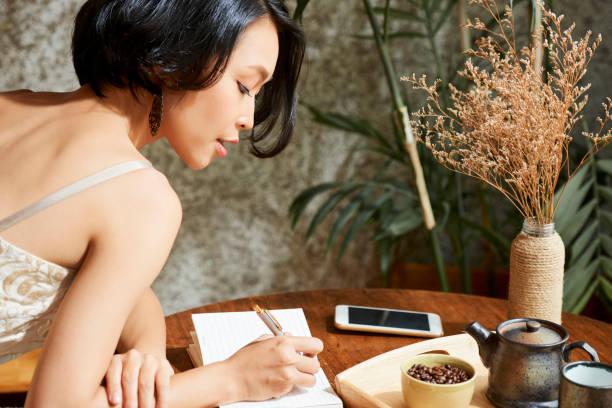 istock Woman filling gratitude journal 1157788878