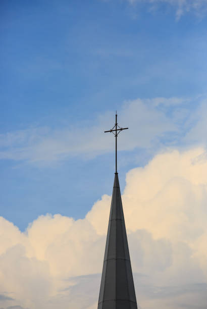 istock Spire with a cross on a catholic church building in sky 1157790081