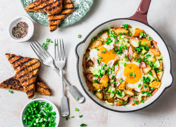 ジャガイモ、ハム、卵の朝食ハッシュは、明るい背景、トップビューにフライパンでハッシュ。おいしい、栄養価の高い朝食、スナック - omelet breakfast eggs onion ストックフォトと画像
