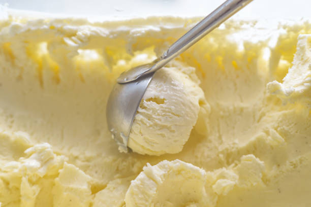 istock Ice cream scooping out of container by metal spoon close up 1157792158