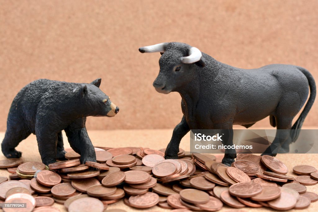Bull vs Bear Market Bull and Bear Toys on a Pile of Money. Concept for Stock Market. Bull - Animal Stock Photo