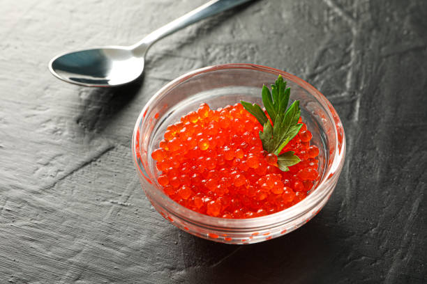 istock Glass jar with caviar and spoon on black background, space for text 1157797197