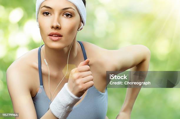 A Young Woman Running While Listening To Music Stock Photo - Download Image Now - Active Lifestyle, Activity, Adult