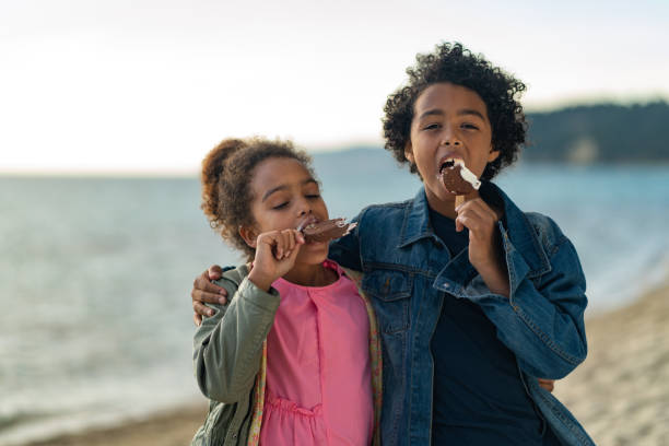istock Kids enjoying ice cream on the beach 1157800074