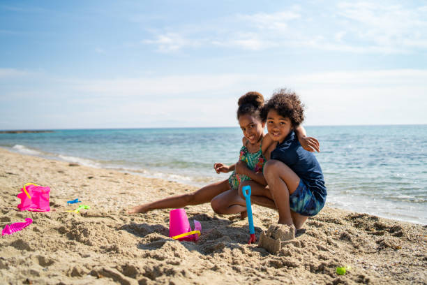 istock Kids playing with sand on the beach 1157800222