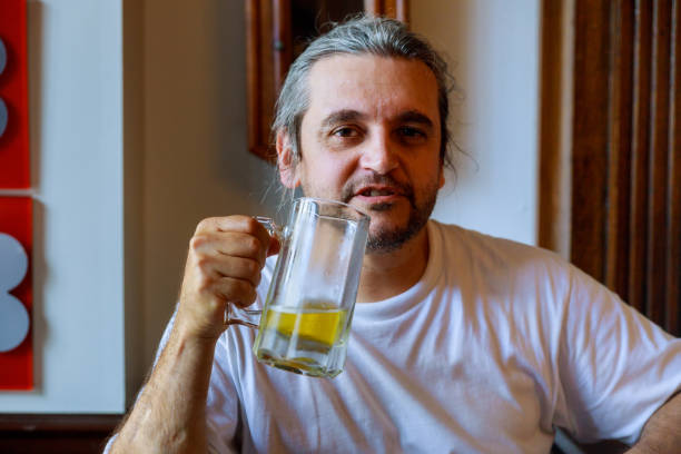 istock Young man drinking beer in glass bock, could be student or alcoholic. 1157801574